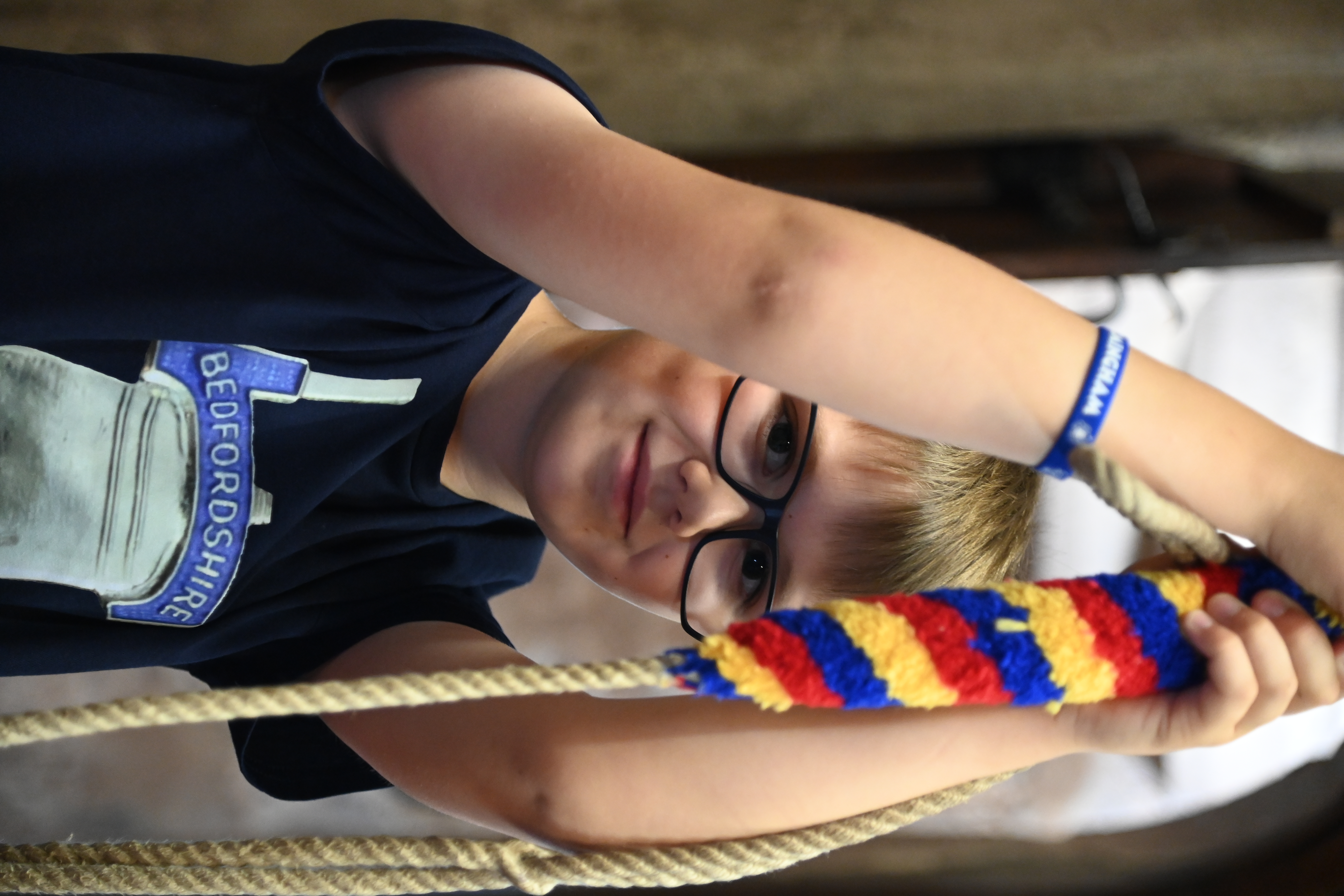 A young bellringer concentrating at the rope